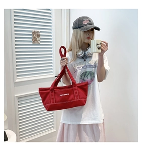 Detailed view of red canvas tote bag with LOVEY SUMMER text and thick handle straps
