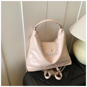 Détail de ce sac fourre-tout en cuir verni rose avec dentelle et boutons décoratifs