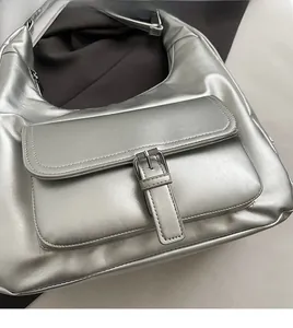 Close-up of metallic silver hobo bag featuring front flap pocket and adjustable buckle detail