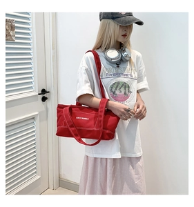 Detail view of red canvas tote bag featuring Lovey Summer text and wide shoulder strap