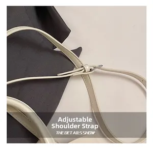Detail van verstelbare schouderriem met zilveren gesp op een beige luxe emmer handtas