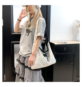 Detail of canvas tote bag featuring colorful polka dots and drawstring closure