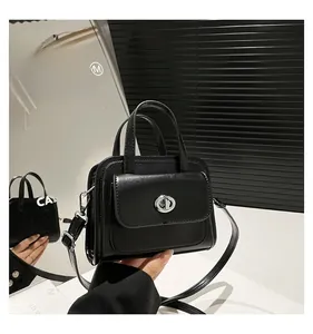 Dettaglio della borsa nera minimalista con chiusura a scatto in argento e pelle opaca