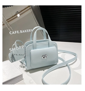 Dettaglio mini borsa azzurra con chiusura a scatto argento e tracolla sottile