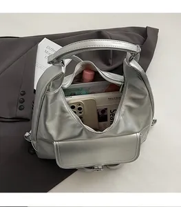 Close-up of spacious silver metallic tote bag interior showing daily items and storage capacity