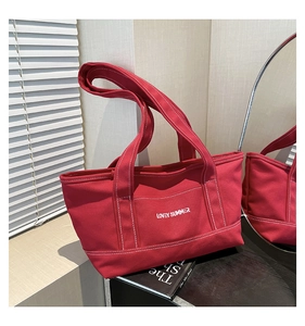 Detail view of red canvas tote bag with contrast stitching and Lovey Summer print
