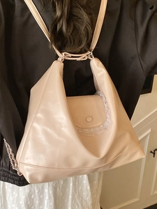 Sac fourre-tout minimaliste en cuir beige avec dentelle et chaîne porté par modèle