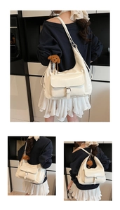Detail of white moon tote bag with front buckle pocket and cute brown teddy bear charm
