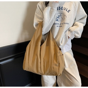 Close-up of khaki tote bag side pockets and textured fabric on casual shoulder bag