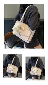 Detail view of pink leather tote bag with metal lock pocket and white plush bunny charm