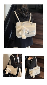 White rectangle messenger bag with silver lock and plush bunny charm shown on shoulder