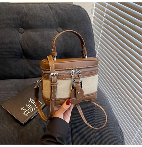Détails des coutures et de la poignée du sac à main bicolore en cuir et toile de coton
