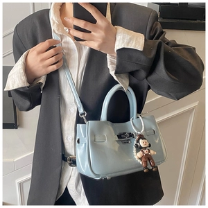Detail van lichtblauwe emmer-tas van lychee-leer met zilveren metalen draaisluiting
