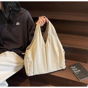 Close-up of beige canvas tote bag with a minimalist design and spacious shoulder strap