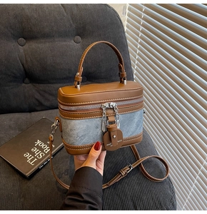Détail du sac boîte contrasté associant cuir PU marron et patchwork en denim bleu vintage