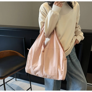Detail of light pink large tote bag with pleated fabric texture and wide shoulder straps