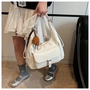 White glossy PU tote bag detail with decorative buckle pocket and plush puppy charm