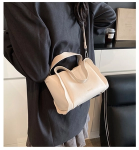 Detailed macro view of the cream white bucket bag featuring premium lychee grain leather texture