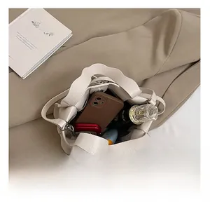 Spacious interior of off-white lychee leather bucket bag showing everyday essentials