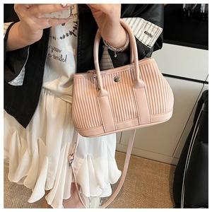 Detail of pink pleated PU leather bucket bag with silver metal swivel lock and strap