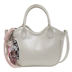 Bolso tipo cubo de cuero crema con borde ondulado y adorable colgante de perro de peluche