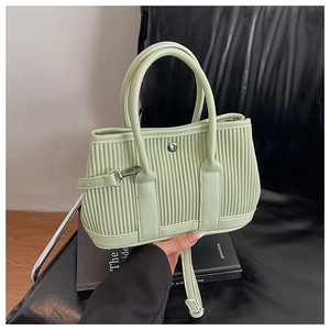 Close-up of pleated mint green bucket bag featuring a silver ring buckle and thin strap