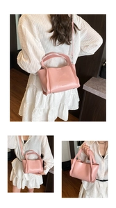 Detailed view of pink lychee grain bucket bag featuring MUDUO logo and silver hardware