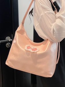 Pink glossy faux leather tote bag with a lace bow detail, stylish hobo shoulder bag