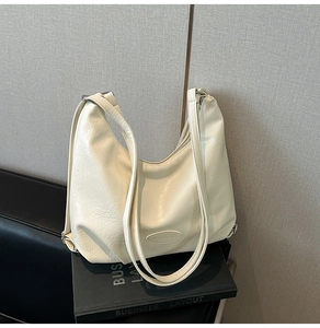 Détail du sac en similicuir crème avec texture plissée vintage et finitions métalliques argent