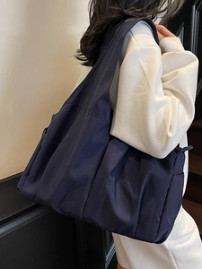 Large navy blue nylon tote bag with multi-pocket design shown on model for daily commuting