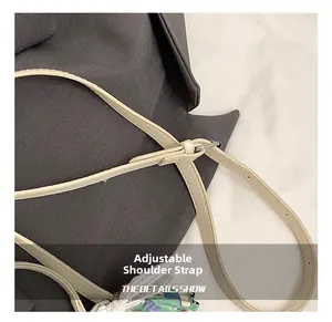 Détail de la bandoulière réglable en cuir beige avec boucle métallique et perforations