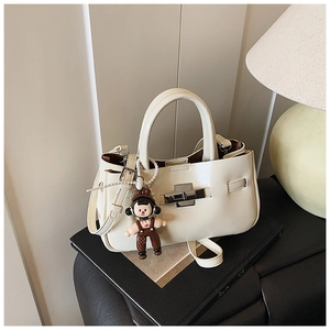 Detail van off-white emmertas met zilveren draaisluiting en een cartoon hanger
