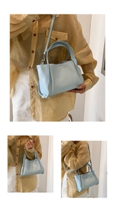 Detail view of light blue lychee pattern leather bucket bag with embossed MUDUO brand logo