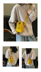Detail of yellow nylon drawstring crossbody bag with circular logo and side woven label