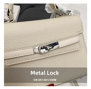 Détail du fermoir tournant en argent et du cuir grainé sur le sac à main crème