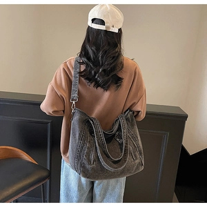 Sac cabas en jean gris vieilli avec large bandoulière réglable vue de dos sur mannequin