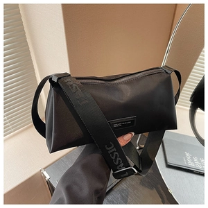 Détail d'un sac bandoulière en nylon noir avec une large sangle et texte CLASSIC blanc