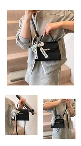 Détail du sac en cuir grainé noir avec nœud en dentelle et pendentif en perles amovible