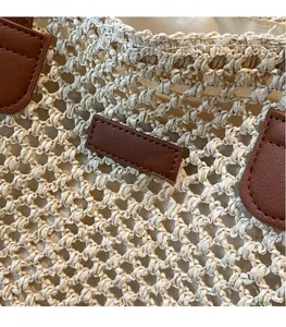 Détail de la texture tissée à la main et des empiècements en cuir marron du sac de plage