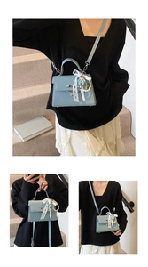 Détail du sac en cuir grainé bleu clair avec fermoir rotatif argenté et breloques perles