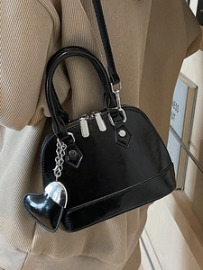 Elegant black patent leather shell handbag with mirror finish and silver hardware charms