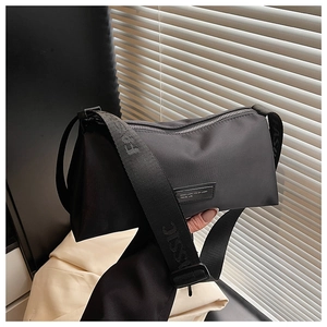 Détail du sac bandoulière en nylon noir avec bandoulière réglable à logo gaufré