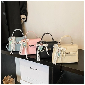 Détail de mini sacs à main en cuir grainé avec nœuds en dentelle et perles