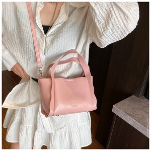 Close-up of pink bucket bag featuring lychee leather texture and metallic studs