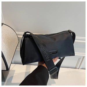 Détail de la bandoulière en nylon avec lettrage fashion et sac à bandoulière noir élégant