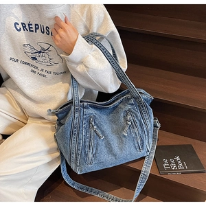 Détails de la texture du sac cabas en denim bleu avec fermetures éclair parallèles