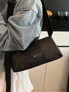 Sac bandoulière minimaliste en nylon noir avec large sangle pour les trajets quotidiens
