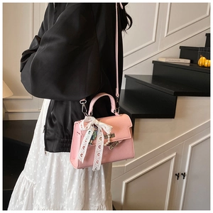 Détails du sac en cuir rose avec nœud en dentelle et accessoires de perles raffinés