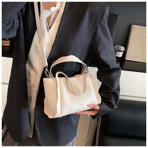 Detail view of cream bucket bag with lychee grain leather and wavy side folds