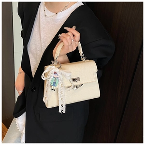 Détail du sac à main blanc cassé en cuir grainé avec fermoir argenté et nœud dentelle